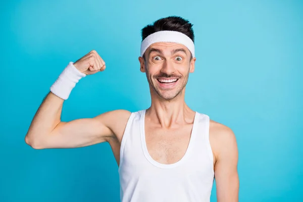 Photo of cheerful astonished man arm flex biceps beaming smile look camera isolated on blue color background — Stock Photo, Image