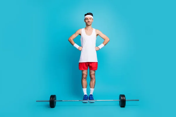 Foto corpo pieno di giovane sportivo confuso esitare palestra di allenamento bilanciere isolato su sfondo di colore blu — Foto Stock