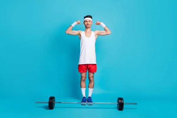 Foto corpo pieno di giovani mani flex bicipiti smorfia viso isolato su sfondo di colore blu pastello — Foto Stock