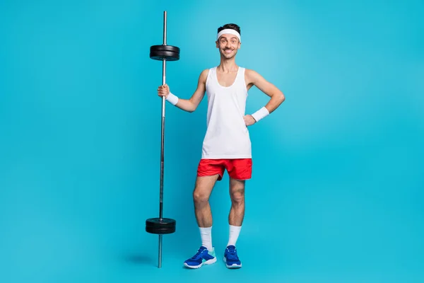 In voller Länge Foto von jungen dünnen Mann glücklich positive stolz Übung Gewichtheben isoliert über blaue Farbe Hintergrund — Stockfoto