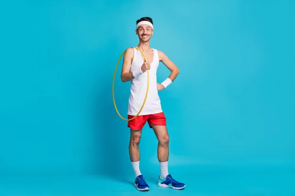 Full size ritratto di uomo allegro fuori mano in vita tenere hula hoop sorridente isolato su sfondo di colore blu — Foto Stock