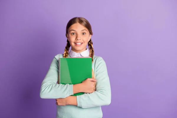 Photo portrait of positive schoolgirl holding copybooks isolated on vivid purple colored background with blank space — Stock Photo, Image