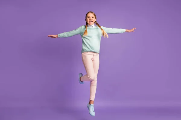 Фотопортрет повний вид на тіло смішної дівчини, що розтягує руки, як літак, що стрибає вгору ізольовано на яскраво-фіолетовому фоні — стокове фото