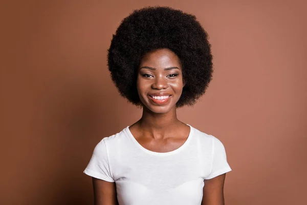Foto portrét veselá žena na sobě ležérní bílé tričko s úsměvem izolované na hnědé barvy pozadí — Stock fotografie