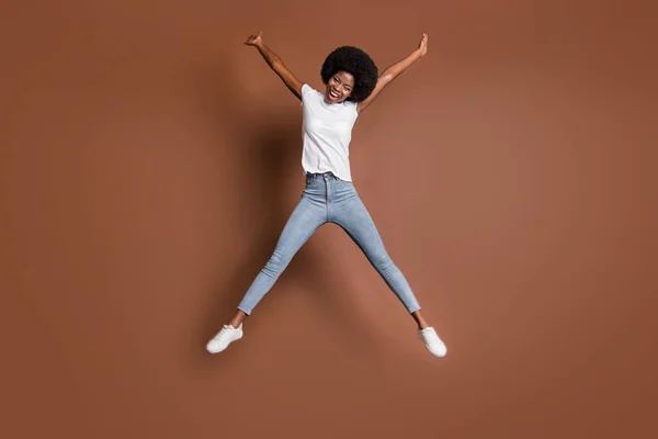 Tamanho do corpo de comprimento total foto de menina saltando alta brincalhão infantil alegrou-se isolado no fundo de cor marrom — Fotografia de Stock