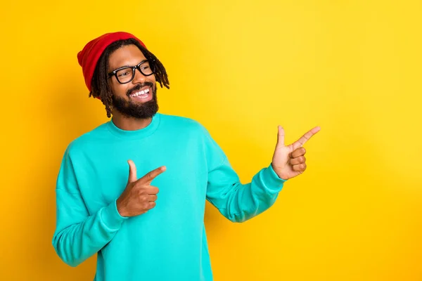 Foto de joven africano hombre feliz sonrisa positiva indican dedo vacío espacio ad promo consejo aislado sobre fondo de color amarillo — Foto de Stock