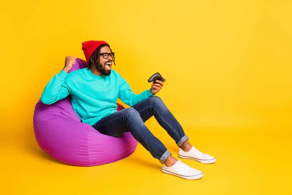 Full size profiel zijkant foto van jonge Afrikaanse man gelukkig positieve glimlach verheugen overwinning video game geïsoleerd over gele kleur achtergrond — Stockfoto