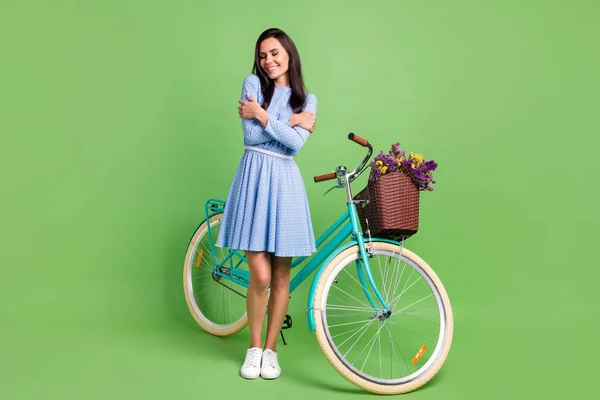 Foto de corpo inteiro da senhora cabelo marrom otimista abraçar-se com vestido de desgaste de bicicleta isolada no fundo verde — Fotografia de Stock