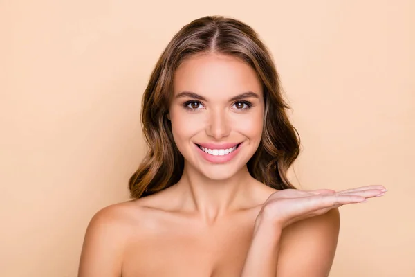 Foto av ung vacker leende flicka bära ingenting hålla hand annonsera hudvård produkt isolerad på pastell färg bakgrund — Stockfoto