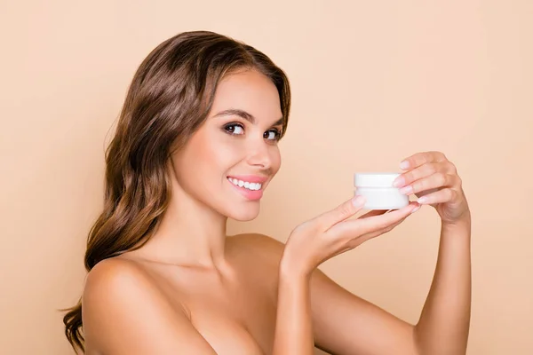 Foto von jungen lächelnden Frau tragen keine Kleidung Werbung feuchtigkeitsspendende Creme isoliert auf beige Hintergrund — Stockfoto