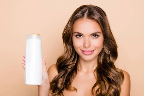 Foto von jungen schönen lächelnden Frau Werbung Shampoo Conditioner isoliert auf beige Hintergrund — Stockfoto