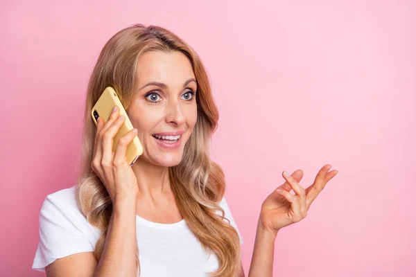 Fotografie pěkné optimistické blond dáma mluvit telefon nosit bílé tričko izolované na pastelové růžové pozadí — Stock fotografie