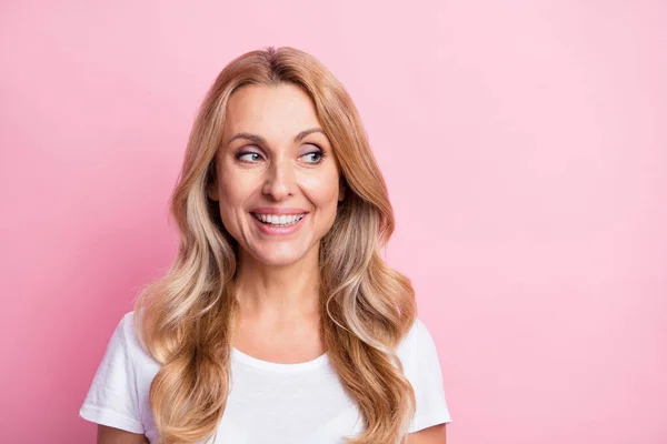 Foto de la señora rubia optimista linda mirada espacio vacío desgaste camiseta blanca aislada sobre fondo de color rosa pastel — Foto de Stock