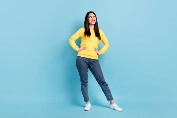 Photo of curious cute lady hands hips look empty space wear yellow jumper jeans shoes isolated blue background — Stock Photo, Image