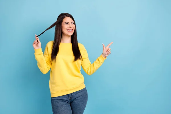 Foto di flirty curioso signora dito diretto su look spazio vuoto usura giallo maglione isolato sfondo blu — Foto Stock