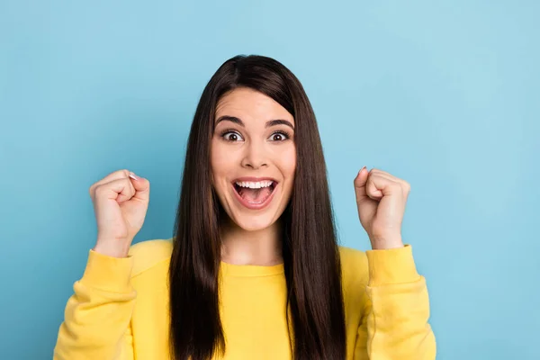 Foto van vrolijke verbaasd dame open mond schreeuwen verhogen vuisten dragen gele jumper geïsoleerde blauwe achtergrond — Stockfoto