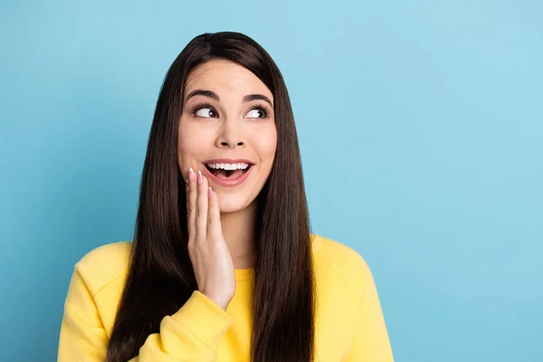 Portret van mooie onder de indruk brunette lang kapsel dame kijken lege ruimte dragen geel shirt geïsoleerd op helder blauwe kleur achtergrond — Stockfoto