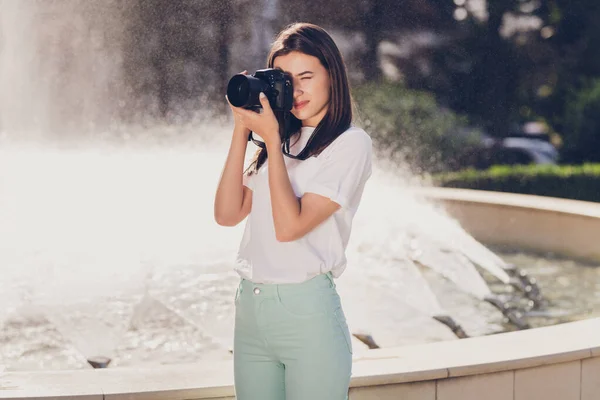 Фотопортрет девушки, фотографирующей с камерой, запечатлевающей вид на город, идущий возле фонтана — стоковое фото