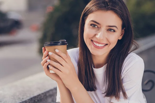 Retrato fotográfico de una chica feliz tomando café al aire libre usando una camiseta casual — Foto de Stock