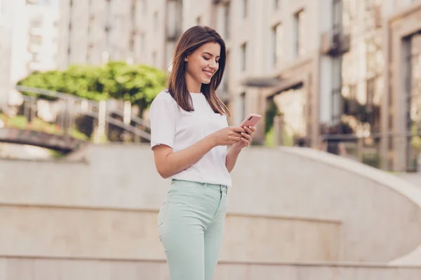 Foto portret van mooi meisje met behulp van mobiele telefoon browsen internet met behulp van app op mobiele telefoon lopen othe straat — Stockfoto