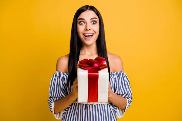 Photo de jeune femme drôle impressionnée habillée robe hors épaules tenant boîte cadeau gros arc isolé fond de couleur jaune — Photo