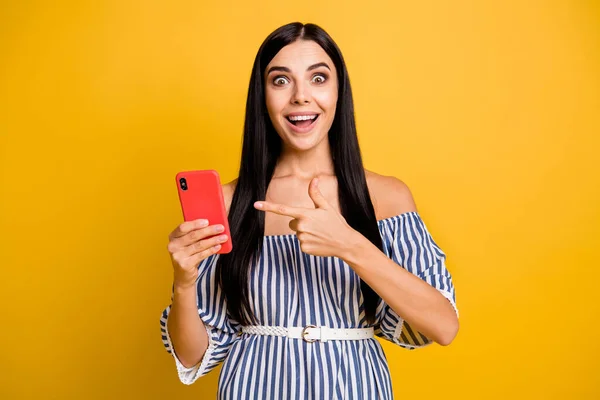 Foto de mulher engraçada impressionado vestido off-ombros vestido apontando dedo gadget moderno isolado cor amarela fundo — Fotografia de Stock