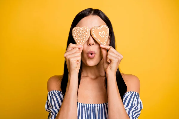 Photo de jeune femme drôle enfantine habillée hors épaules robe coeur gâteaux couvrir les yeux isolé fond de couleur jaune — Photo