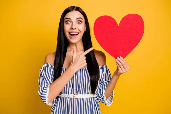 Foto van dromerige onder de indruk vrouw gekleed off-schouders outfit wijzend vinger rood hart lege ruimte geïsoleerde gele kleur achtergrond — Stockfoto