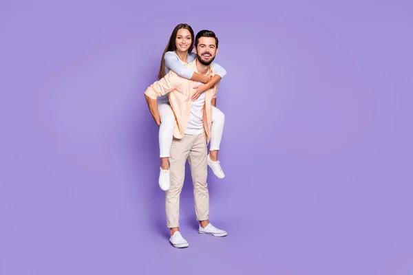 Foto de perfil em tamanho completo de pessoas despreocupadas homem piggyback senhora olhar câmera isolada no fundo cor violeta — Fotografia de Stock