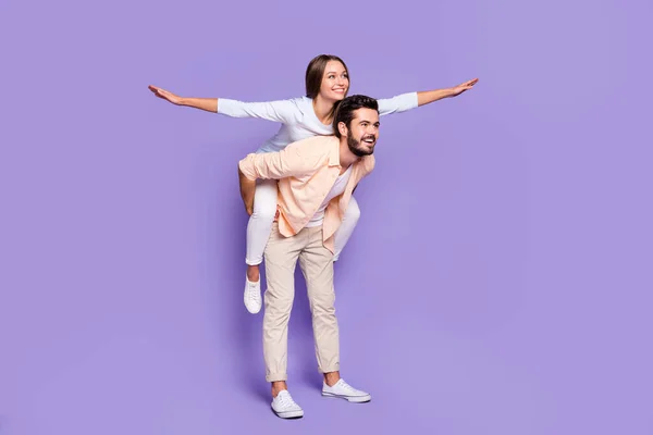 Retrato de perfil em tamanho completo de homem alegre piggyback bonita senhora olhar espaço vazio isolado no fundo de cor roxa — Fotografia de Stock