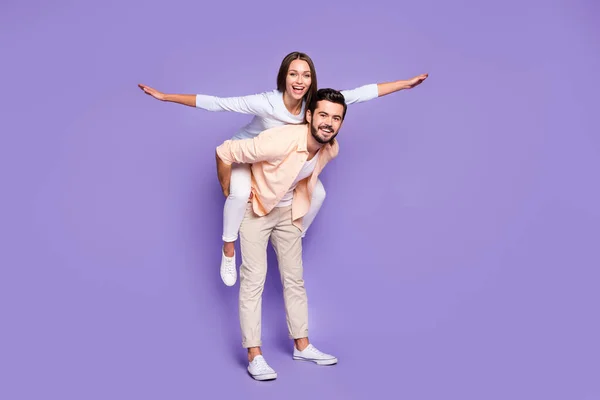 Plná velikost fotografie manželského páru piggyback bavit víkend ruce křídla létat izolované na fialové barvy pozadí — Stock fotografie