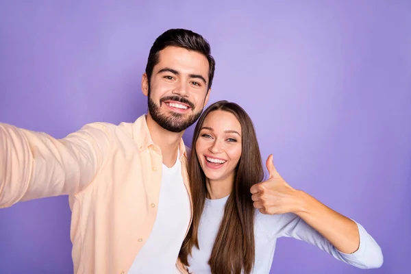 Foto de morena moderna casal elegante fazer polegar para cima tirar selfie câmera encantador sorriso isolado no fundo cor violeta — Fotografia de Stock