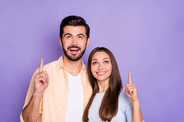 Foto van bruinharige echtgenoten wijzen vingers copyspace boven nieuwheid verkoop geïsoleerd op violette kleur achtergrond — Stockfoto