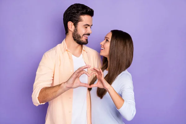 Foto de casal romântico feliz olhar uns para os outros fazer dia dos namorados forma de coração isolado no fundo cor violeta — Fotografia de Stock