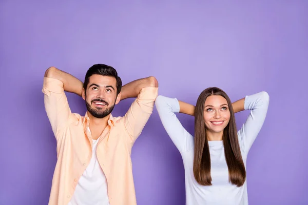 Foto av positiv söt dam stilig kille armar bakom huvudet slå upp tomt utrymme isolerad på violett färg bakgrund — Stockfoto