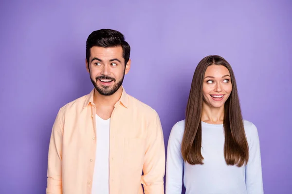 Foto de casal alegre usar camisola azul camisa laranja olhar copyspace espantado isolado no fundo cor roxa — Fotografia de Stock