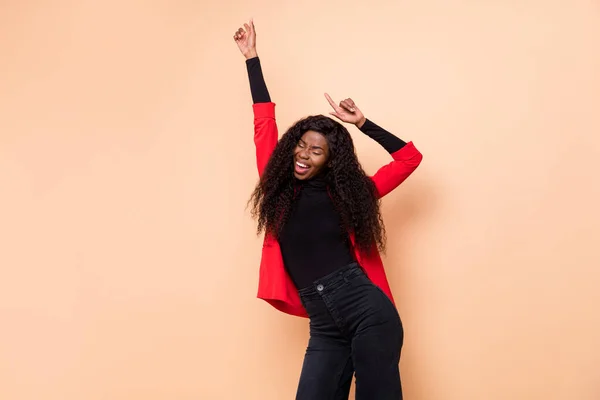 魅力的な幸せなアフロアメリカの若い女性の写真パステルベージュの色の背景に隔離された手のダンスを上げる — ストック写真