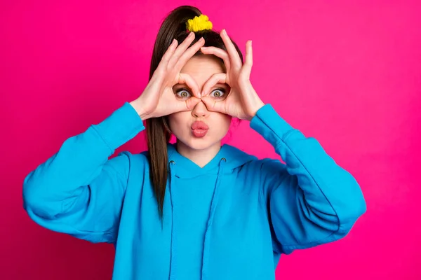 Foto van positief kinderachtig meisje tonen vingers verrekijker ogen kussen lippen geïsoleerd op roze kleur achtergrond — Stockfoto