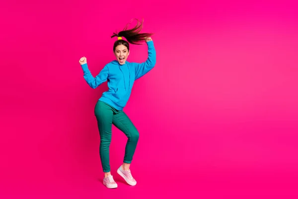 Foto de comprimento total de impressionado jovem mulher vestida azul com capuz dança mãos braços punhos isolado vibrante cor de fundo rosa — Fotografia de Stock