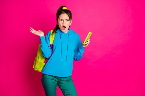 Φωτογραφία από σοκαρισμένη νεαρή κοπέλα φορούν μπλε σακίδιο πουλόβερ κρατώντας σύγχρονη συσκευή κενό χώρο απομονωμένο ροζ χρώμα φόντο — Φωτογραφία Αρχείου