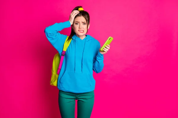 Φωτογραφία της ένοχης θλιμμένης γυναίκας ντυμένη μπλε hoodie σακίδιο gadget χέρι χέρι κεφάλι κενό χώρο απομονωμένο ροζ χρώμα φόντο — Φωτογραφία Αρχείου