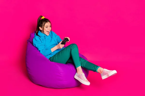 Foto de comprimento total de impressionado senhora desgaste azul suéter relaxante violeta beanbag desfrutar de playstation isolado cor rosa fundo — Fotografia de Stock