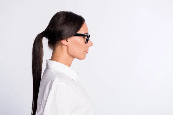 Profil zdjęcie optymistyczne brunetka fryzjerka pani w pobliżu puste miejsce nosić okulary biała koszula izolowane na szarym tle kolor — Zdjęcie stockowe