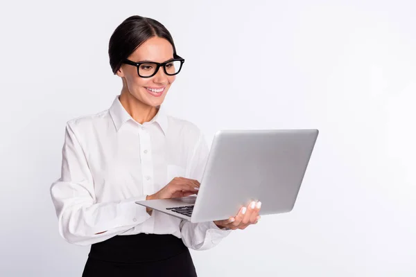 Foto de otimismo morena penteado senhora segurar laptop desgaste óculos camisa isolada no fundo de cor cinza — Fotografia de Stock