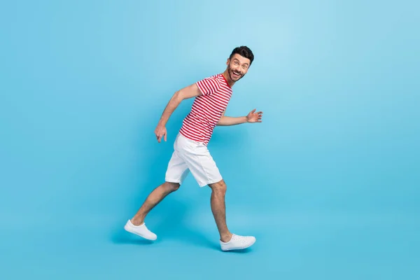 Πλήρες μέγεθος προφίλ πλευρά φωτογραφία του χαρούμενα θετική νεαρός άνδρας με τα πόδια τρέχει κενό χώρο απομονωμένο σε παστέλ φόντο μπλε χρώμα — Φωτογραφία Αρχείου