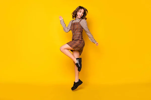 フル長さボディサイズの写真の女子高生ジャンプ笑い服を着て再生ユニフォーム独立した鮮やかな黄色の背景 — ストック写真