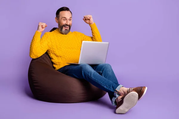 Fullt kroppsbilde av en moden mann glad smil, vinn seiersknyttneve, se laptop isolert over fiolett fargebakgrunn – stockfoto
