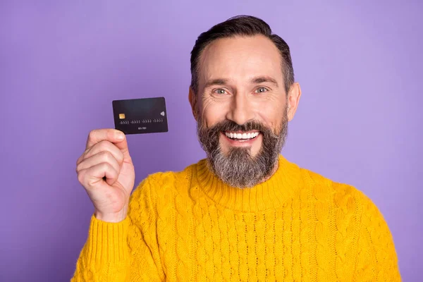 Foto de alegre hombre de negocios feliz sonrisa positiva celebrar tarjeta de crédito comprar ingresos salariales aislados sobre fondo de color violeta — Foto de Stock