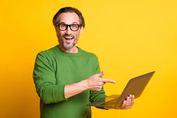 Фотографія людини, що тримає ПК, вказує, що палець відкритий рот носить окуляри зелений пуловер ізольований жовтий колір фону — стокове фото