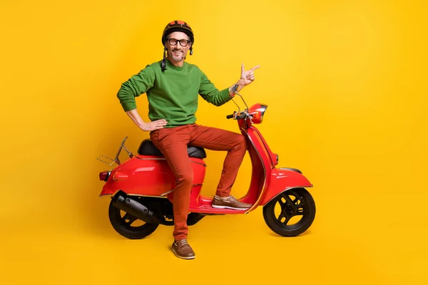 Adamın scooter sürerken fotoğrafı. Direkt boş parmak. Kask, gözlük, yeşil süveter. — Stok fotoğraf